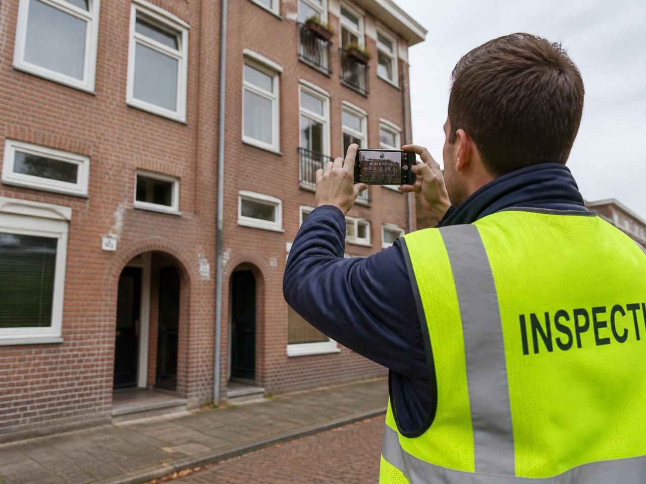Inspector photographing a brick facade with a smartphone for a NEN 2767 condition assessment